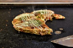 Chef cooking okonomiyaki (okonomi-yaki)